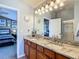 Bathroom featuring double sinks, granite countertop, light fixtures, and a doorway to the bedroom at 6821 Breezy Palm Dr, Riverview, FL 33578