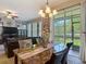 Elegant dining area with a marble table, chandelier lighting, and access to the outdoor patio at 6821 Breezy Palm Dr, Riverview, FL 33578