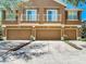 Attractive townhome featuring a three-car garage with charming exterior architectural details at 6821 Breezy Palm Dr, Riverview, FL 33578