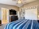 Cozy bedroom with a blue striped comforter, vaulted ceiling, and a door leading to the bathroom at 6821 Breezy Palm Dr, Riverview, FL 33578