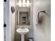 Well-lit powder room with a pedestal sink, chrome faucet, and towel rack at 6821 Breezy Palm Dr, Riverview, FL 33578