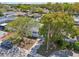 Aerial view of the property showcasing the front yard, mature trees, and driveway in a suburban setting at 7034 N King Arthur E Dr # 4, Port Richey, FL 34668