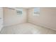 Bright bedroom features neutral paint, tiled floors, two windows and wall air conditioning unit at 7034 N King Arthur E Dr # 4, Port Richey, FL 34668