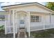 Welcoming entrance featuring a decorative archway, white picket fence and brick-paved pathway at 7034 N King Arthur E Dr # 4, Port Richey, FL 34668