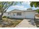 Cozy single-story home with a well-manicured lawn, white picket fence, and attached garage at 7034 N King Arthur E Dr # 4, Port Richey, FL 34668