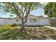 Attractive single-story home with lush green lawn and mature tree providing ample shade at 7034 N King Arthur E Dr # 4, Port Richey, FL 34668