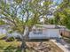 Quaint one-story home featuring a manicured lawn, charming picket fence, and mature tree in the front yard at 7034 N King Arthur E Dr # 4, Port Richey, FL 34668