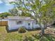 Charming single-story home with a welcoming picket fence, arbor, and mature shade tree in the front yard at 7034 N King Arthur E Dr # 4, Port Richey, FL 34668