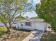 Charming one-story home with well-kept lawn, picket fence, arbor entrance, and a mature tree in the yard at 7034 N King Arthur E Dr # 4, Port Richey, FL 34668