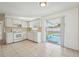 Bright kitchen features white cabinets, tiled countertops and backsplash, white appliances and access to a screened lanai at 7034 N King Arthur E Dr # 4, Port Richey, FL 34668