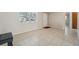 Spacious living room featuring neutral paint, tile floors, a large front window and an entry door at 7034 N King Arthur E Dr # 4, Port Richey, FL 34668