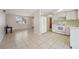 Bright living room with tile floors adjacent to a kitchen featuring white appliances and cabinetry at 7034 N King Arthur E Dr # 4, Port Richey, FL 34668