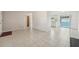 Open living area with tile flooring that connects to the kitchen with natural light from a sliding glass door at 7034 N King Arthur E Dr # 4, Port Richey, FL 34668