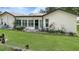 Exterior view of the back of the home featuring a sunroom and a grassy backyard at 7495 Heather Walk Dr, Weeki Wachee, FL 34613