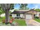Well-maintained home with manicured lawn, colorful flower bed, and brick-accented attached garage at 7495 Heather Walk Dr, Weeki Wachee, FL 34613