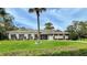 Well-maintained one-story home with manicured lawn, mature landscaping, and neutral color palette at 7495 Heather Walk Dr, Weeki Wachee, FL 34613