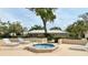 Relaxing hot tub area with lounge chairs, mature landscaping, and a view of the community at 7495 Heather Walk Dr, Weeki Wachee, FL 34613