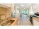 Bright kitchen view showing sink, kitchen and sight lines to living room and sun room at 7495 Heather Walk Dr, Weeki Wachee, FL 34613