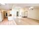 Bright living room featuring neutral carpet, fan, and adjacent kitchen at 7495 Heather Walk Dr, Weeki Wachee, FL 34613