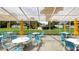 Community patio area with seating, tables, umbrellas, and a view of the surrounding landscape at 7495 Heather Walk Dr, Weeki Wachee, FL 34613