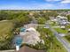 Aerial perspective of houses with screened-in pools, lush foliage, and a tranquil neighborhood vibe at 8200 Rhanbuoy Rd, Spring Hill, FL 34606