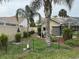 Well-maintained backyard features a privacy fence, lush tropical foliage, and mature palm trees at 8200 Rhanbuoy Rd, Spring Hill, FL 34606