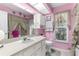 Pink bathroom with a white vanity and countertop with framed mirror above it at 8200 Rhanbuoy Rd, Spring Hill, FL 34606