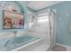 Relaxing bathroom featuring a soaking tub with a glass shower and blue accents at 8200 Rhanbuoy Rd, Spring Hill, FL 34606