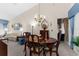 Cozy dining area featuring a chandelier, hardwood table, and chairs near the living space at 8200 Rhanbuoy Rd, Spring Hill, FL 34606