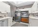 Functional kitchen featuring white cabinets, modern stainless steel refrigerator, and retro oven for culinary creations at 8200 Rhanbuoy Rd, Spring Hill, FL 34606