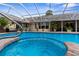 Screened pool with spa, brick trim, and outdoor furniture at 8200 Rhanbuoy Rd, Spring Hill, FL 34606