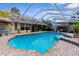 Large screened pool with brick trim, attached spa and nearby lounge area at 8200 Rhanbuoy Rd, Spring Hill, FL 34606