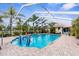 Relaxing screened-in pool with tropical landscaping and cozy seating area for entertaining guests and enjoying the outdoors at 8200 Rhanbuoy Rd, Spring Hill, FL 34606