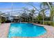 Inviting screened-in pool with brick patio, lush landscaping, and lounge seating for relaxation and outdoor enjoyment at 8200 Rhanbuoy Rd, Spring Hill, FL 34606