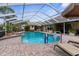 Screened pool with brick trim, and a lounge area with outdoor dining and lounging at 8200 Rhanbuoy Rd, Spring Hill, FL 34606