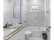 Elegant bathroom features marble tile surround, shower-tub combo, granite vanity, and grey accent wall at 8312 40Th N St, Pinellas Park, FL 33781