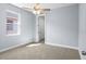 Cozy bedroom features neutral carpet, ceiling fan, and natural light from the window at 8312 40Th N St, Pinellas Park, FL 33781