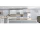 The bright kitchen has white cabinets, marble countertops, stainless steel appliances, and pendant lighting at 8312 40Th N St, Pinellas Park, FL 33781