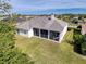 Aerial view of the home showing screened in patio and spacious yard with mature landscaping at 8606 Coral Creek Loop, Hudson, FL 34667