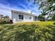 Back exterior view of home showcasing the bright, manicured lawn and neutral paint at 8606 Coral Creek Loop, Hudson, FL 34667