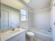 Cozy bathroom featuring a bathtub with shower, white vanity, and tiled walls at 8606 Coral Creek Loop, Hudson, FL 34667