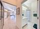 Bright bathroom and hallway featuring tile flooring, sink, and view to an open living space at 8606 Coral Creek Loop, Hudson, FL 34667