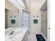 Light and airy bathroom with a glass enclosed shower, large mirror, and access to the outdoors at 8606 Coral Creek Loop, Hudson, FL 34667