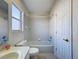 Cozy bathroom featuring a bathtub with shower, white vanity, and tiled walls at 8606 Coral Creek Loop, Hudson, FL 34667