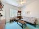Relaxing bedroom with a futon, carpeted floors, and a well-lit atmosphere with ample natural light at 8606 Coral Creek Loop, Hudson, FL 34667
