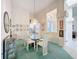 Formal dining room showcasing chandelier, glass table, white chairs, botanic art, transom window at 8606 Coral Creek Loop, Hudson, FL 34667
