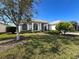 Exterior of home showing meticulous landscaping, mature trees and neutral exterior paint at 8606 Coral Creek Loop, Hudson, FL 34667