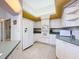 Well-lit kitchen featuring white cabinets, tiled floors, and modern appliances at 8606 Coral Creek Loop, Hudson, FL 34667