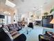 Large living room with tall ceilings, ceiling fan, and a fireplace with built in bar at 8606 Coral Creek Loop, Hudson, FL 34667