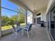 View of screened patio with table and chairs, ceiling fan and a grill near the sliding glass doors at 8606 Coral Creek Loop, Hudson, FL 34667